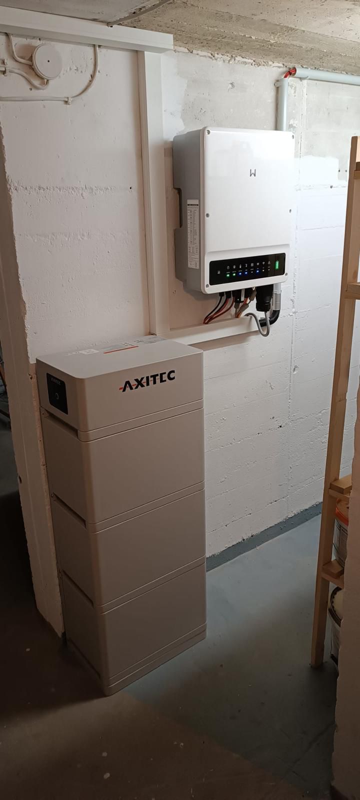 Ein Energiespeichersystem in einem Keller an einer Betonwand montiert.