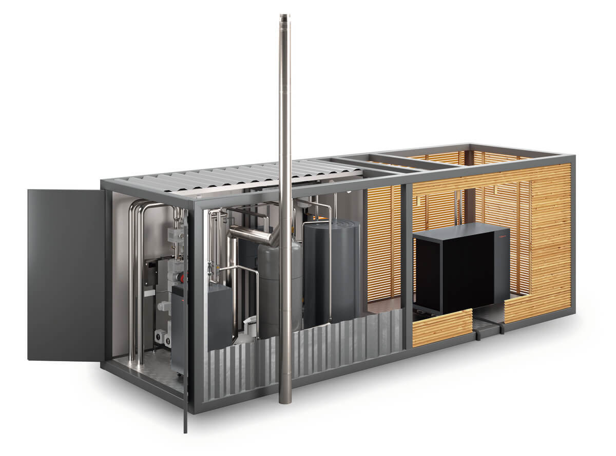 Metallischer Container mit technischen Geräten, teils Holzverkleidung, Rohrleitungen sichtbar.